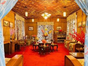 a living room filled with furniture and a red carpet at Houseboat Bendmeer Heritage in Srinagar +2 photos