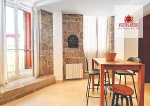 a table and chairs in a room with a brick wall at Exclusivo no centro histórico in Vila Real