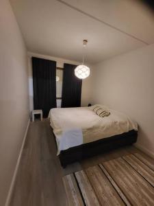 1 dormitorio con cama y lámpara de araña en Two bedroom apartment right next to Santapark, en Rovaniemi