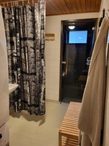 y baño con cortina de ducha y lavamanos. en Two bedroom apartment right next to Santapark en Rovaniemi