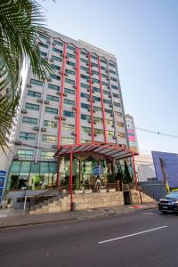 a tall building with a restaurant in front of it at Hotel Golden Park Curitiba in Curitiba