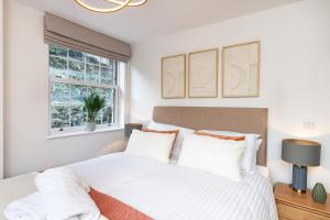 1 dormitorio con 1 cama con sábanas blancas y ventana en Rock Mill Apartment 22, en Stony Middleton