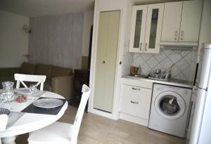 - une cuisine avec une table et un lave-linge dans l'établissement Appartement lumineux et calme - La Foux-Mercantour, à Allos