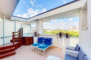 a balcony with blue chairs and a staircase at Hotel Buratti in Cervia