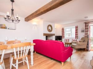 a living room with a red couch and a table at 3 Bed in Burton Bradstock DC055 in Burton Bradstock