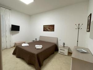 a bedroom with a bed with two towels on it at Domus Atenea in Agrigento
