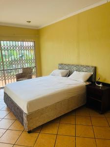 duże łóżko w pokoju z oknem w obiekcie Spacious peaceful 5 bedroom house w mieście Pretoria