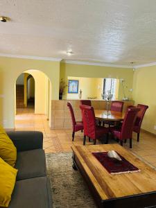 a living room with a couch and a table and chairs at Spacious peaceful 5 bedroom house in Pretoria