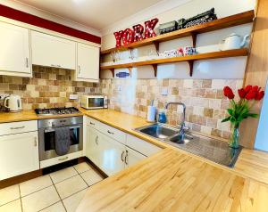 Una cocina con gabinetes blancos y un fregadero. en Cosy Victorian Apartment - Central York, en York 3 fotos más