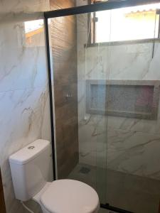 een badkamer met een toilet en een glazen douche bij Chalé Buriti in Bonito