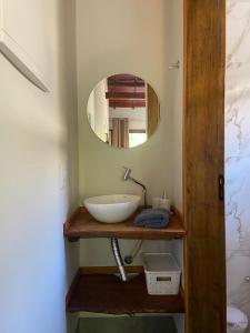 een badkamer met een wastafel en een spiegel bij Chalé Buriti in Bonito