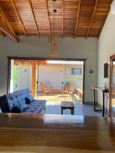 Chalé Buriti في بونيتو: غرفة معيشة مع أريكة زرقاء وطاولة