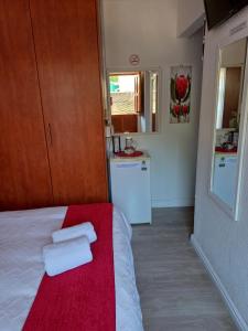 um pequeno quarto com uma cama com toalhas em La Grâce, Durbanville em Cidade do Cabo