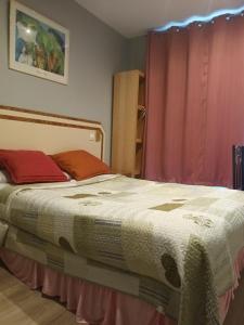 パリにあるhotel azurのベッドルーム1室(赤いカーテン付きのベッド1台付)