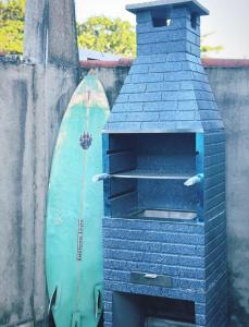a blue brick oven with a surfboard next to it at Casa de Praia Beira Mar Bali Beach House in Bertioga