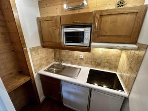 uma pequena cozinha com um lavatório e um micro-ondas em Appartement Les Menuires, 2 pièces, 5 personnes - FR-1-452-250 em Les Menuires