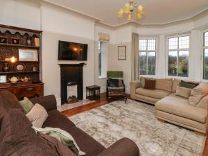 a living room with two couches and a fireplace at Tirallen in Llanwrda