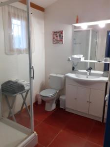 a white bathroom with a toilet and a sink at Petit Paradis chez Pascale et Bernard in Cazouls-lès-Béziers