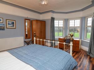 a bedroom with a bed with a blue comforter at Tirallen in Llanwrda