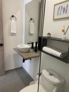 a bathroom with a white toilet and a sink at Deko rooms in Arauca