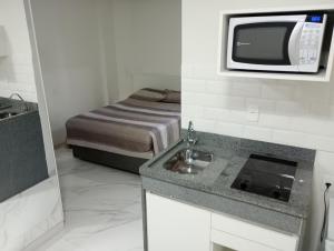 a small kitchen with a sink and a microwave at Carillon Plaza Hotel in São Paulo
