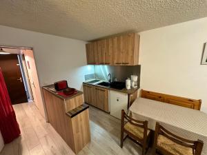 a small kitchen with a table and a small kitchen with a bed at Studio Corrençon-en-Vercors, 1 pièce, 4 personnes - FR-1-515-52 in Corrençon-en-Vercors