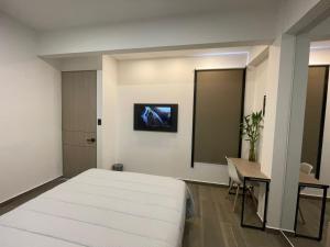 Dormitorio con cama, escritorio y TV en Deko rooms, en Arauca