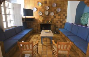 ウブリケにあるCasa Rural Veinte Pilaresの青いベンチ、テーブル、テレビが備わるレストラン