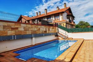 uma casa com piscina em frente a uma casa em Villa Luisa Apartment em Somo