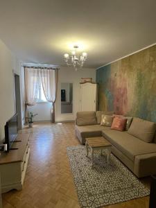 uma sala de estar com um sofá e uma televisão em THE FIRST em Trieste