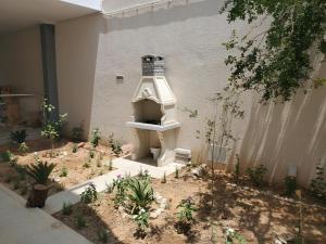 a garden with a bird house in the middle of a building at Omnia House in Monastir