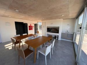 uma cozinha e sala de jantar com mesas e cadeiras em Edificio Pinheiros em Punta del Este