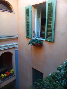 a building with green shutters and a balcony with flowers at Casa di Emanuela in Spello