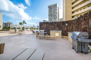 een patio met banken en een stenen muur bij Renovated Modern Design Waikiki Condo Nice Views in Honolulu