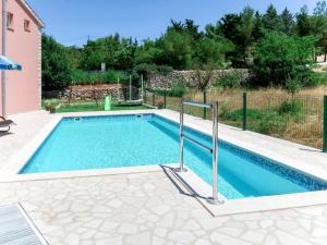 a swimming pool with blue water in a yard at Poolside Paradise in Srijane