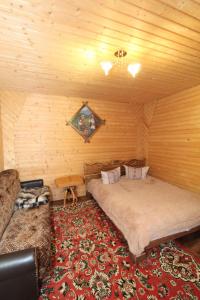 um quarto com uma cama e um sofá num quarto em Садиба "Svitlana" em Yablunytsya