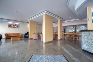 a lobby with a couch and a table and chairs at Hotel Golden Park Curitiba in Curitiba