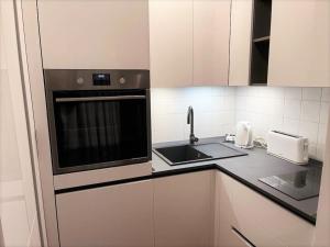 a small kitchen with a sink and a microwave at Appartement Vars, 3 pièces, 8 personnes - FR-1-330B-141 in Vars