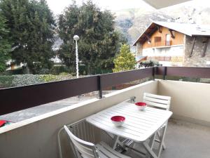 a white table and two chairs on a balcony at Appartement T2 pour 6 personnes, balcon, parking, St-Lary-Soulan - FR-1-457-142 in Saint-Lary-Soulan