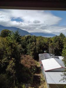een uitzicht op de bergen en bomen vanuit een gebouw bij Casa Aoni in Puerto Montt