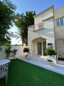 uma casa com um relvado em frente em Charming villa w/ private garden em Dubai