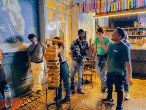 a group of men standing in a room playing a video game at Viajero Kokopelli Lima - Barranco Hostel in Lima