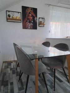 a dining room with a glass table and chairs at Apartman Mihaela in Laktaši