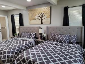 ein Schlafzimmer mit 2 Betten und ein Baumgemälde an der Wand in der Unterkunft Big new house with huge parking in West Seneca