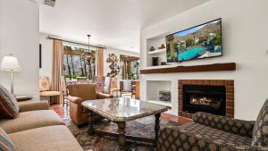 a living room with a fireplace and a tv at SV113 Airy Spa Villa 1 Bedroom in Prime Location in La Quinta