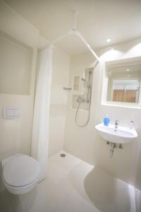 a white bathroom with a toilet and a sink at Muffin Hostel in Salzburg