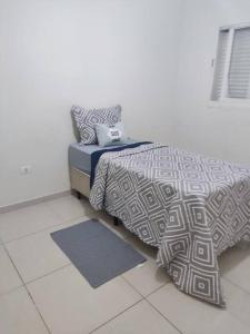 uma cama num quarto com um espectro de roupa de cama em Casa rústica Jardim Abaete em Piracicaba