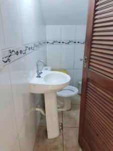 a bathroom with a sink and a toilet at Casa rústica Jardim Abaete in Piracicaba