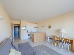 een woonkamer en een keuken met een bank en een tafel bij Studio Châtelaillon-Plage, 1 pièce, 4 personnes - FR-1-535-22 in Châtelaillon-Plage