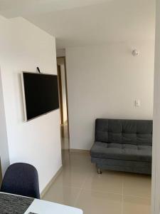 een woonkamer met een bank en een flatscreen-tv bij Apartamento nuevo norte Cali in Cali